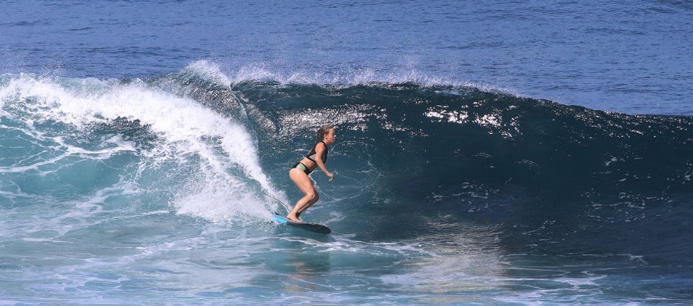 Una chica surfeando en el campamento Loredo Surf House